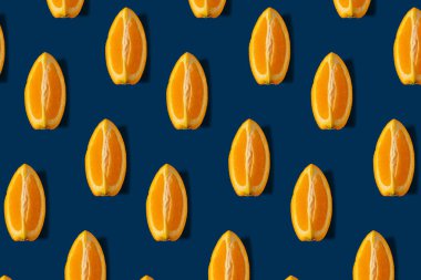 Mavi arka planda portakal meyvesi olan yaratıcı yaz konsepti. Keskin gölgeli en az model..