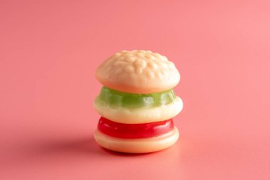 Pembe arka planda renkli şekerli hamburger. En az gıda konsepti.