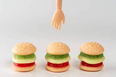 Bebek eli ile renkli şekerli hamburgerler. En az gıda konsepti.