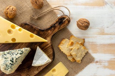 Beyaz ahşap masada değişik peynir çeşitleri var. Peynir arkaplanı.