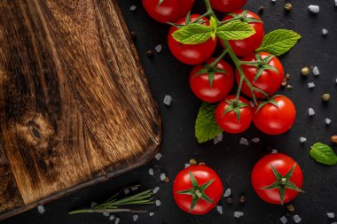 Siyah arka planda baharatlı taze kiraz domatesleri. Yemek arkaplanı. Üst görünüm.