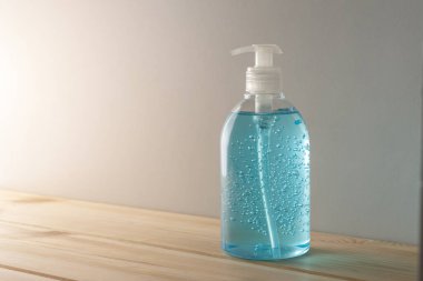 Ahşap masadaki şişede el dezenfektanı. Coronavirus önleme kavramı.