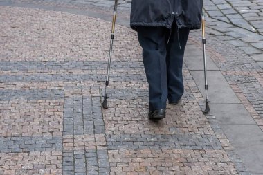 Prag, Çek Cumhuriyeti 'nde sokakta yürüyüş direğiyle yürüyen kıdemli bir bayan..