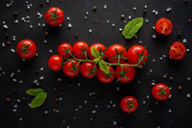 Siyah arka planda baharatlı taze kiraz domatesleri. Yemek arkaplanı. Üst görünüm.