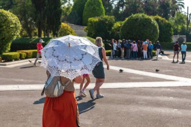 ATENS, GREECE - 30 Ekim 2019: Sokakta beyaz şemsiyeli kadın.