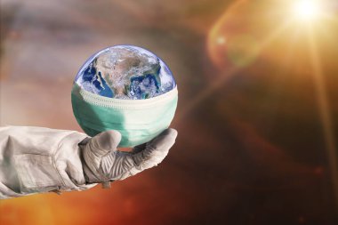 Yüzü maske takan Dünya gezegeni astronot elinde korunuyor. Dünya tıbbi konsepti. Bu görüntünün elementleri NASA tarafından desteklenmektedir.
