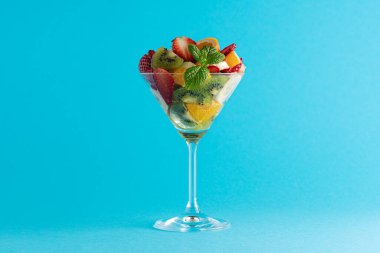 Parlak arka planda martini bardağında meyve kokteyli. Asgari gıda vegan konsepti.