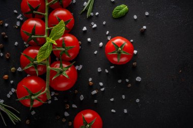 Siyah arka planda baharatlı taze kiraz domatesleri. Yemek arkaplanı. Üst görünüm.