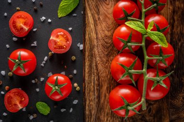 Siyah arka planda baharatlı taze kiraz domatesleri. Yemek arkaplanı. Üst görünüm.