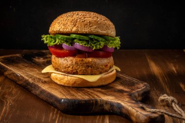 Ahşap kırsal masada taze lezzetli burger manzarası. Gıda arkaplanı.