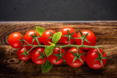 Ahşap arka planda baharatlı taze kiraz domatesleri. Yemek arkaplanı. Üst görünüm.
