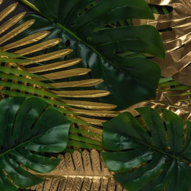 Siyah arka planda altın ve yeşil tropikal palmiye yaprakları olan yaratıcı bir düzen. Minimum yaz soyut şablonu.