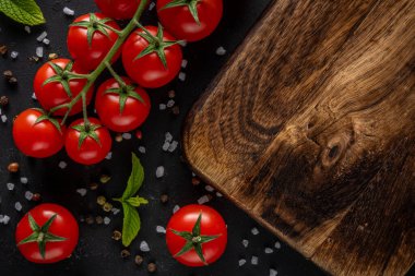 Siyah arka planda baharatlı taze kiraz domatesleri. Yemek arkaplanı. Üst görünüm.