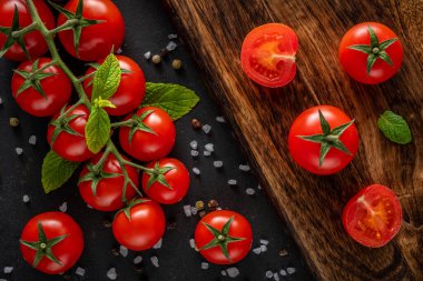 Siyah arka planda baharatlı taze kiraz domatesleri. Yemek arkaplanı. Üst görünüm.