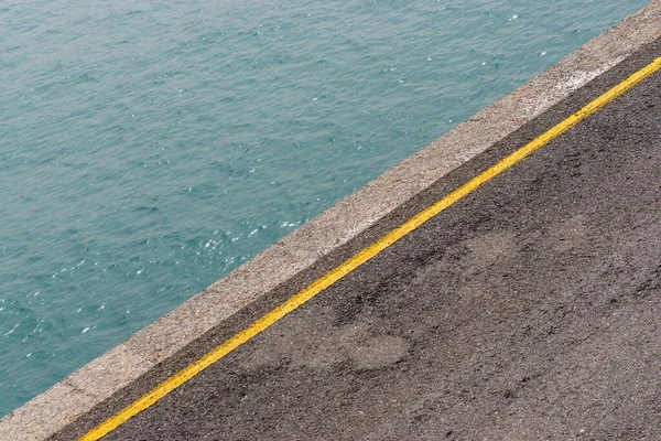 Vista Uma Doca Porto Com Uma Linha Amarela Asfalto Mar — Fotografia de Stock