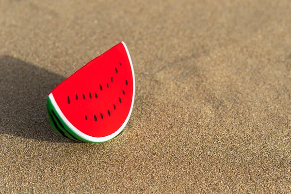 砂の背景にスイカのおもちゃ 最小限の夏休みのコンセプト — ストック写真