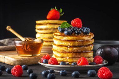 Koyu arkaplanda taze böğürtlenli leziz krepler. Yiyecek konsepti.