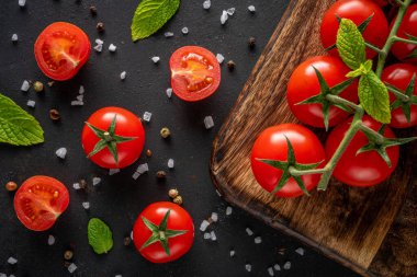 Siyah arka planda baharatlı taze kiraz domatesleri. Yemek arkaplanı. Üst görünüm.