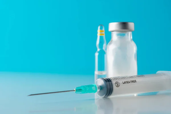 Skleněná Injekční Lahvička Vakcínou Injekční Stříkačkou Modrém Pozadí Koncept Očkování — Stock fotografie