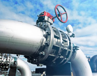 Mavi gökyüzüne karşı sanayi bölgesi, çelik boru hatları ve vanalar