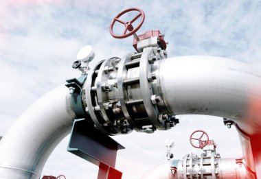 Mavi gökyüzüne karşı sanayi bölgesi, çelik boru hatları ve vanalar