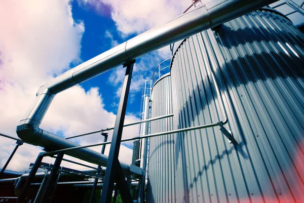 Zona industrial, tuberías de acero y válvulas contra el cielo azul — Foto de Stock