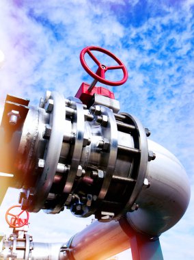 Mavi gökyüzüne karşı sanayi bölgesi, çelik boru hatları ve vanalar