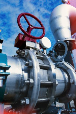 Mavi gökyüzüne karşı sanayi bölgesi, çelik boru hatları ve vanalar