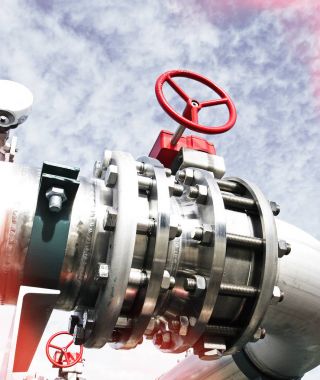 Mavi gökyüzüne karşı sanayi bölgesi, çelik boru hatları ve vanalar