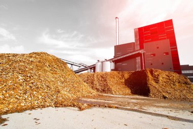 Mavi gökyüzüne karşı ahşap yakıt deposu olan biyo-elektrik santrali