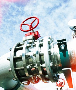 Mavi gökyüzüne karşı sanayi bölgesi, çelik boru hatları ve vanalar