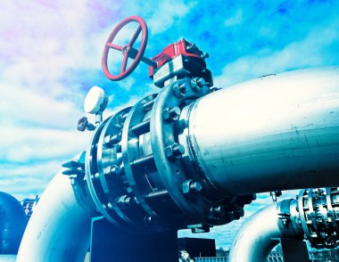 Mavi gökyüzüne karşı sanayi bölgesi, çelik boru hatları ve vanalar