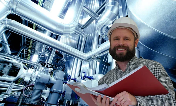 Engineer reading manual against factory equipment — Stock Photo, Image