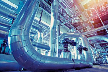 Sanayi bölgesi, çelik boru hatları ve mavi tonlu kablolar.