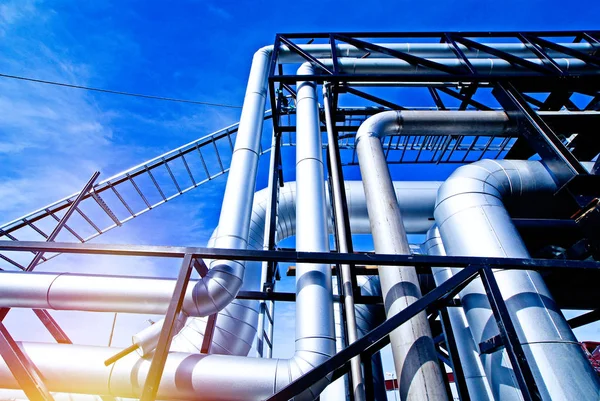 Industrial zone, Steel pipelines and valves against blue sky Stock Photo