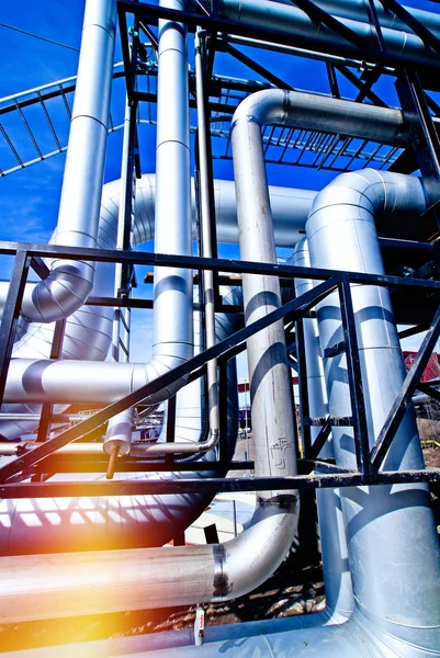 Industrial zone, Steel pipelines and valves against blue sky Stock Photo