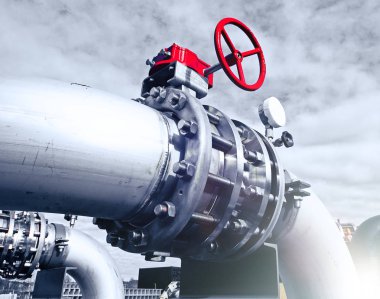 Mavi gökyüzüne karşı sanayi bölgesi, çelik boru hatları ve vanalar