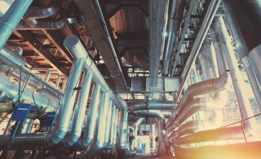 Sanayi bölgesi, çelik boru hatları ve mavi tonlu kablolar.