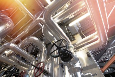 bir enerji santralinde farklı boyutlarda ve şekilli borular ve vanalar 