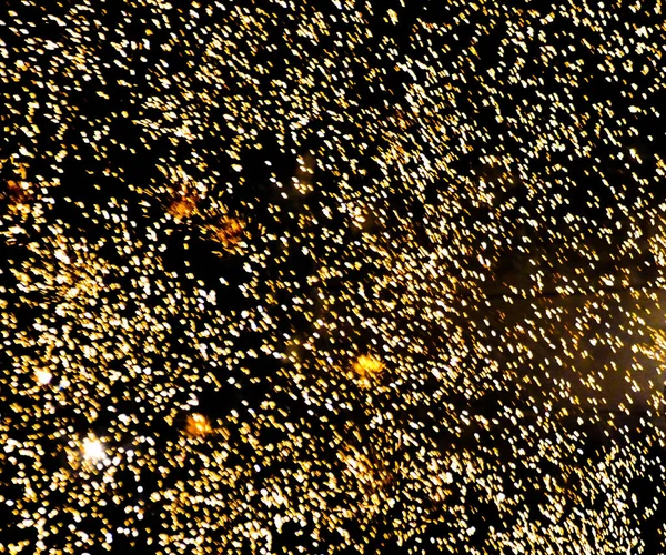 Sparks of yellow salute on a black background