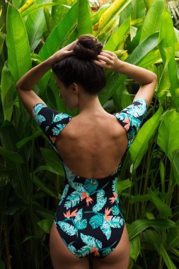Girl is standing with her back in the jungle clipart