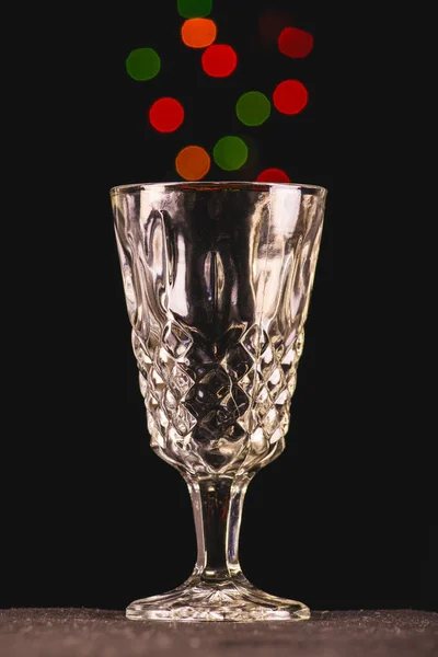 Sirviendo luces de colores en un vaso. Foto tomada con fondo negro y luces de colores.
