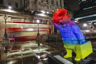 Londra, Uk. Paddington Bear akşam heykeli Bank istasyonu yakınında ve arka planda kırmızı otobüs ile bir İngiltere Bankası görünür 