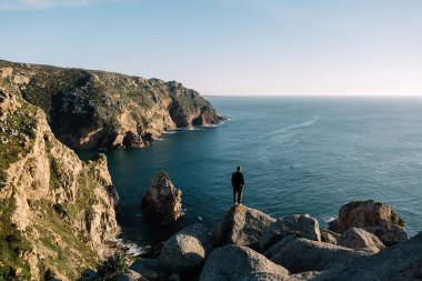 adam okyanusun kıyısında taş kenarına