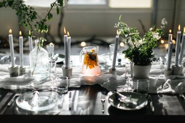 Şık tablo, çatı katı. Çatı katı tarzında dizayn Oda. Siyah masa, sandalye, yemekler, mumlar. Kavanoz yeşillikleri ile.