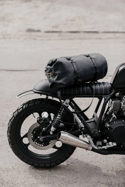 Mochila de cuero cerca de la motocicleta. Moto medio negro en el garaje. Motocicleta kaferacers . —  Fotos de Stock