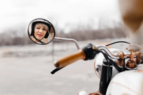 La chica en una motocicleta. Mostrando chicas en el espejo de la motocicleta . Imagen De Stock