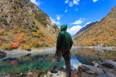 Vadide bizi bekleyen bir yeşil kazak giyen bir adam baktı