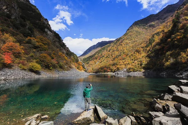 Ein Mann steht am See und fotografiert — Stockfoto