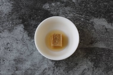 Fermente soya peyniri beyaz bir kase içinde bir parça